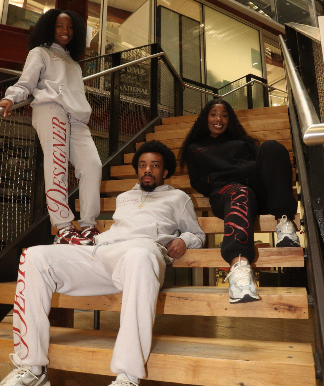 Three people sitting on a staircase in an urban setting
